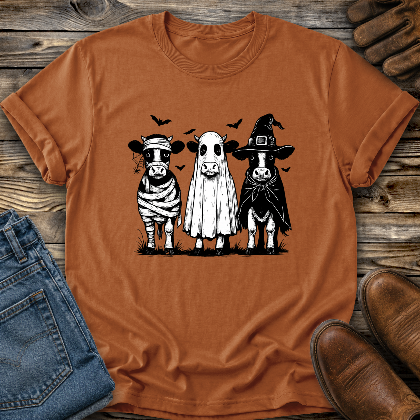 orange tshirt with funny graphic of 3 cow dressed up in halloween costumes