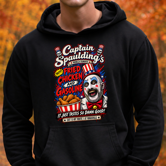 A person wearing a black pullover hoodie with a large colorful graphic print on the chest. The graphic features the text 'Captain Spaulding's' and 'World Famous' with clown and fried chicken illustrations.