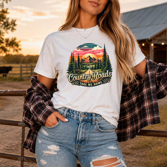 woman wearing white tshirt with country western scene graphic design that says country roads take me home
