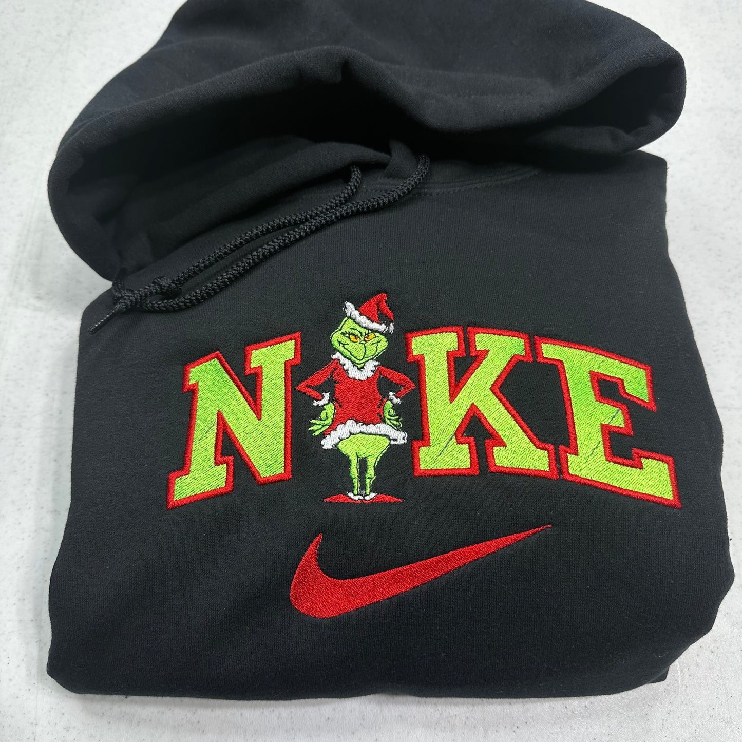 Black hoodie with a Christmas-themed 'Nike' logo on a white background