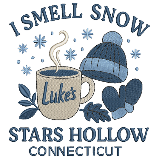 A custom embroidery design featuring a beige mug with 'Luke's' and steam, a blue knit beanie, blue mittens, snowflakes, and the text 'I SMELL SNOW' and 'STARS HOLLOW CONNECTICUT' on a white background.