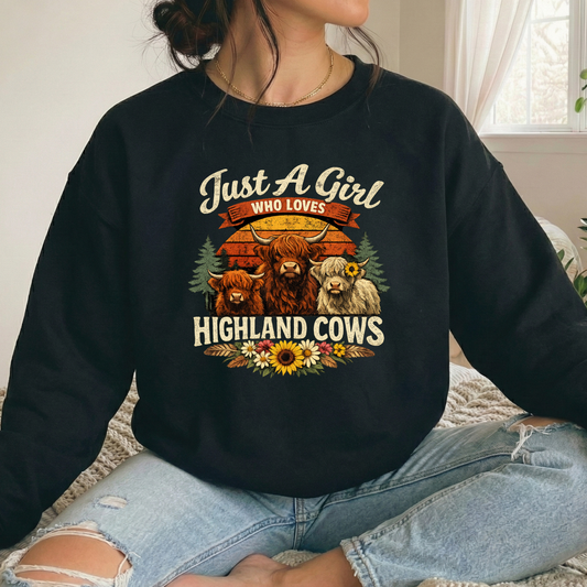 woman wearing a black sweatshirt with highland cows and flowers graphic that says just a girl who loves highland cows