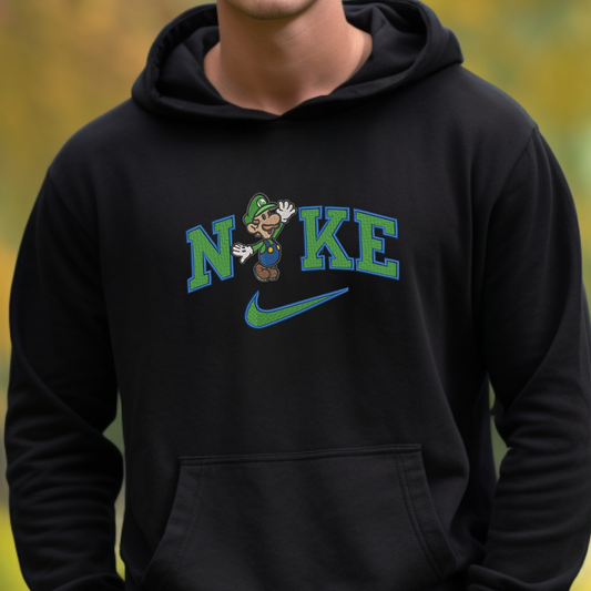A person wearing a black hoodie with a graphic on the chest that reads 'NIKE' in green and blue, featuring a cartoon character and a green swoosh, against a blurred yellow-green outdoor background.