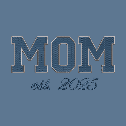 A blue graphic design featuring the word 'MOM' in large varsity-style block letters with a stitched denim-like texture and a tan outline, above the script text 'est. 2025' on a solid blue background.