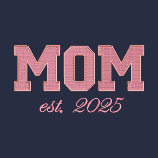 A graphic design featuring the word 'MOM' in large, textured pink varsity-style block letters with a gold outline, above the script text 'est. 2025' in a matching pink color, all set against a solid dark navy blue background.