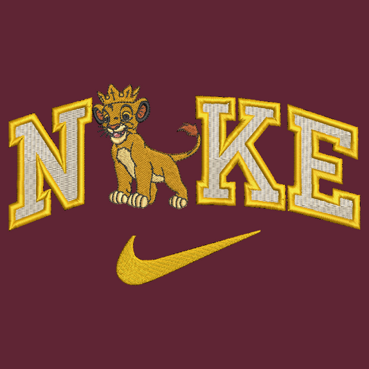 A close-up of a maroon embroidered graphic featuring the word 'N IKE' with a lion cub wearing a crown between the letters, and a gold Nike swoosh below.