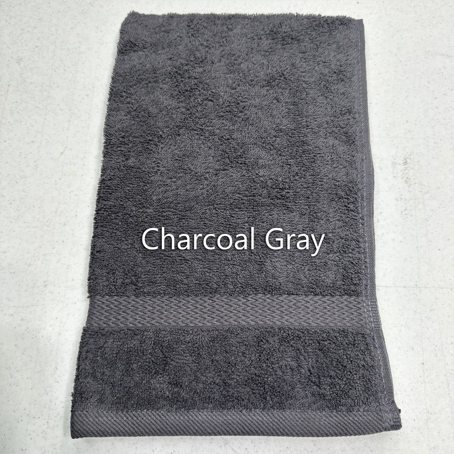 Charcoal gray hand towel on a light gray background