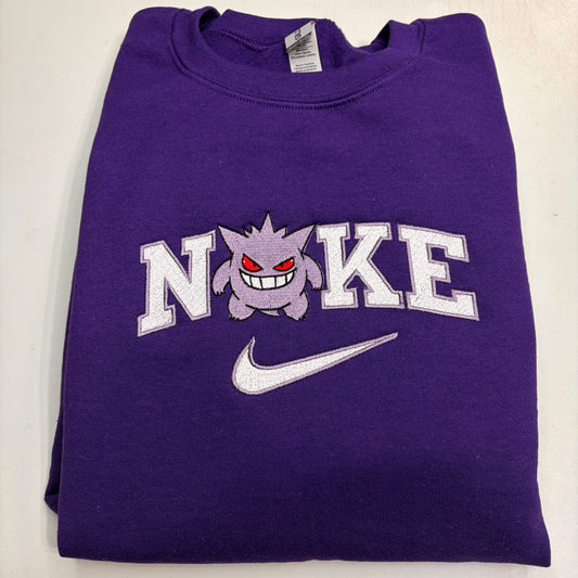 purple sweatshirt with pokemon gengar embroidered design in the nike logo on it