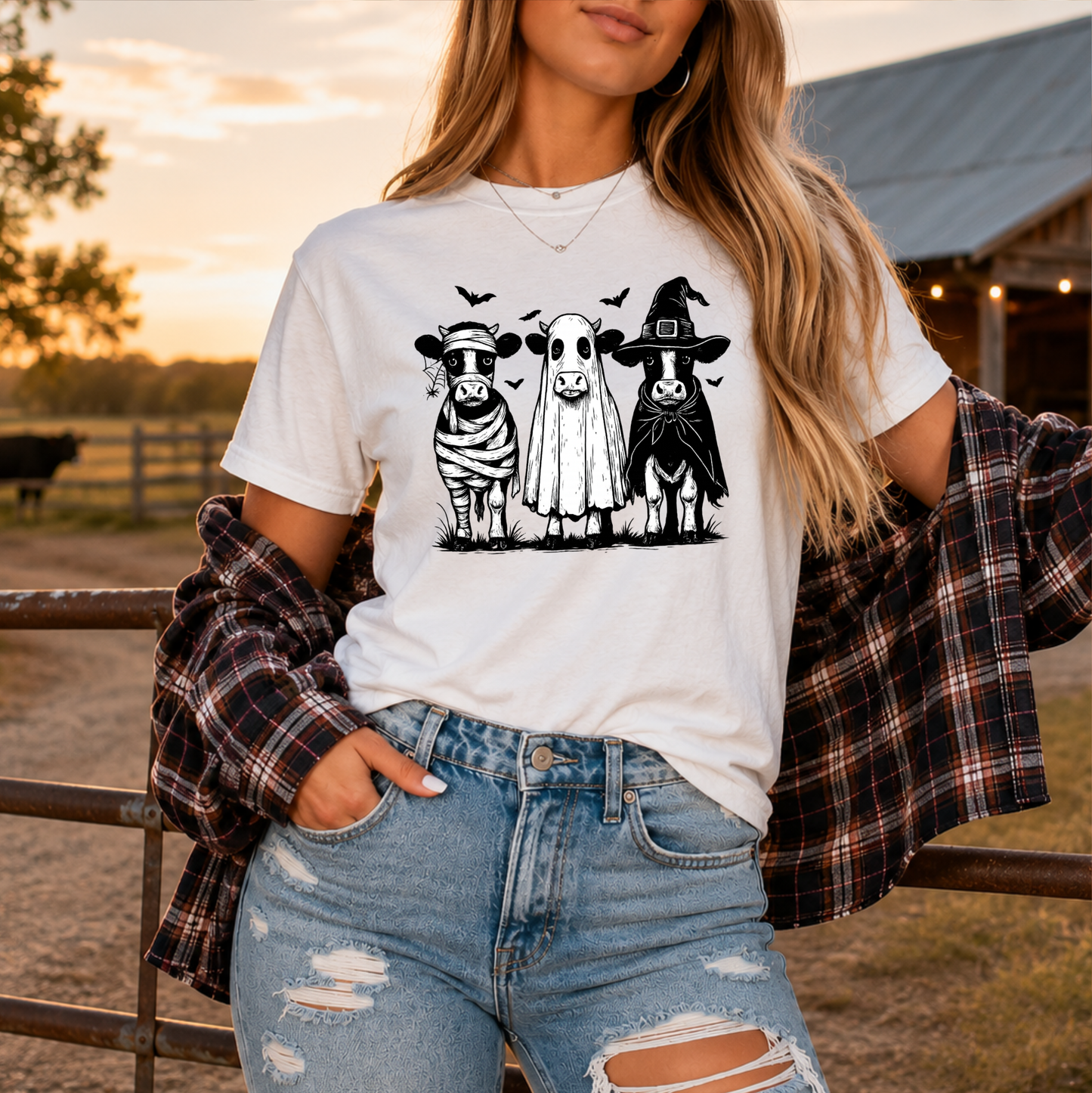 woman wearing a white tshirt with funny graphic of 3 cow dressed up in halloween costumes