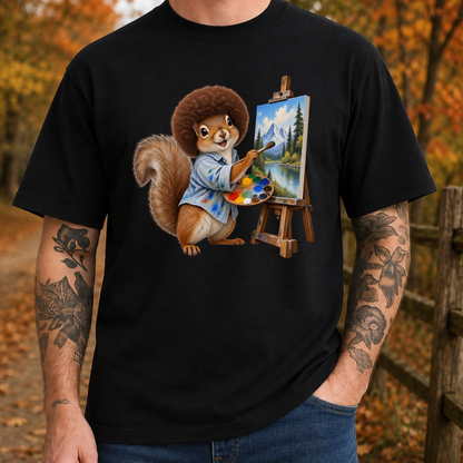 A man wearing a black crewneck t-shirt with a colorful graphic of a squirrel painting a landscape on an easel, set against an autumn outdoor background.
