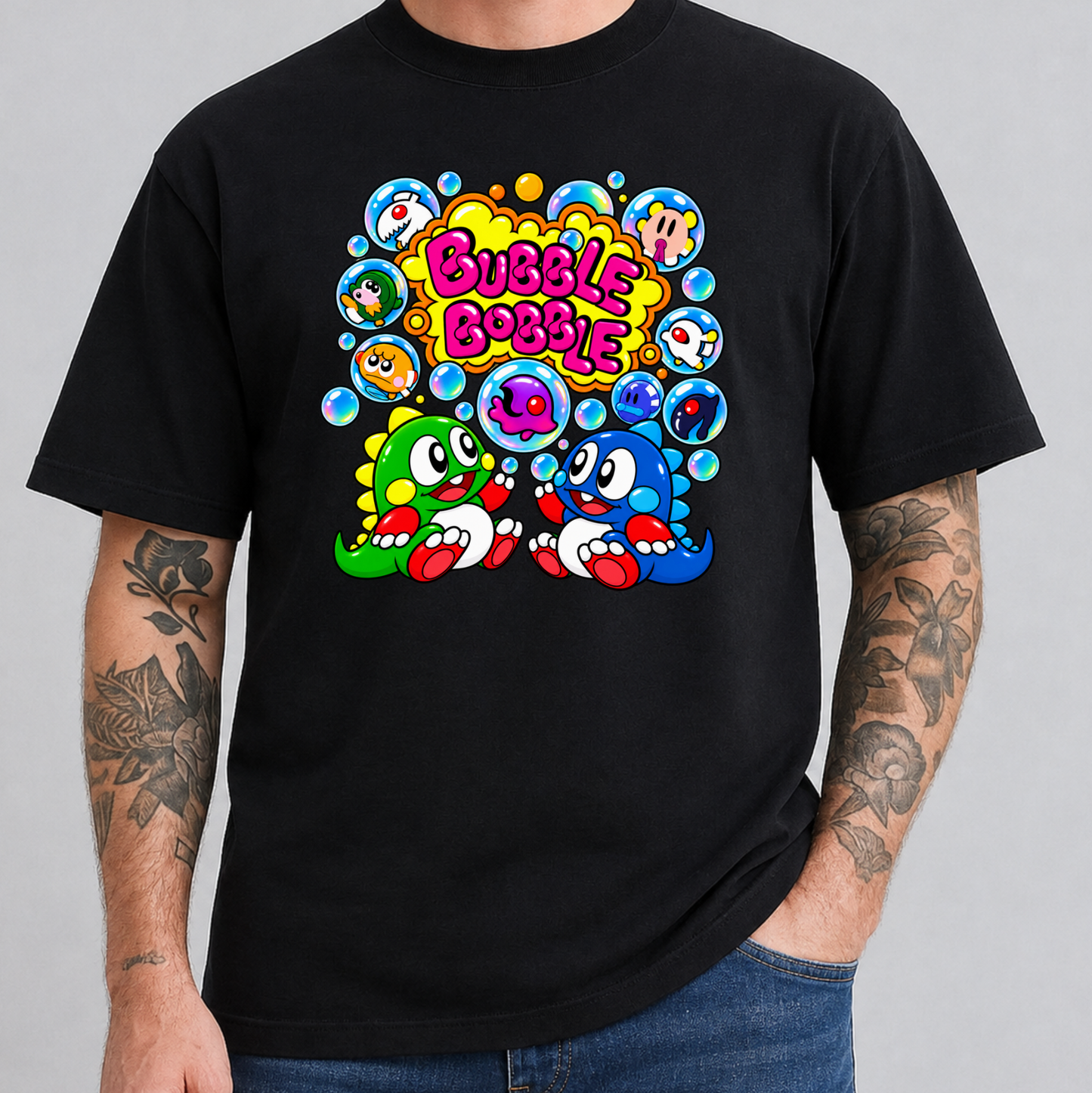 A man wearing a black t-shirt with a colorful retro cartoon graphic on the chest featuring the text 'Bubble Bobble' and two cartoon characters, shown against a plain gray background.