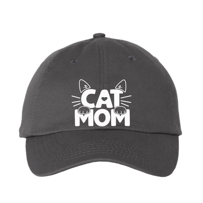 A dark gray dad hat baseball cap featuring a white graphic on the front that reads 'CAT MOM' with cat ears, whiskers, and paws.