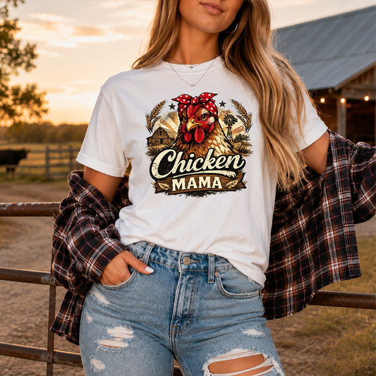 woman wearing a white tshirt with a country farm scene and  a chicken with a bandana on and it says chicken mama
