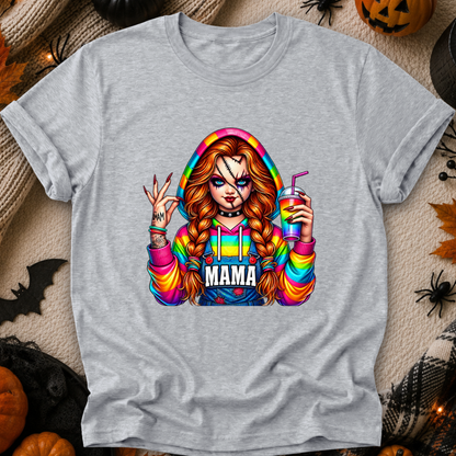 A heather gray short-sleeve t-shirt featuring a colorful graphic of Chucky in a rainbow hoodie with 'MAMA' printed across the chest, styled in a flat lay with Halloween decorations.
