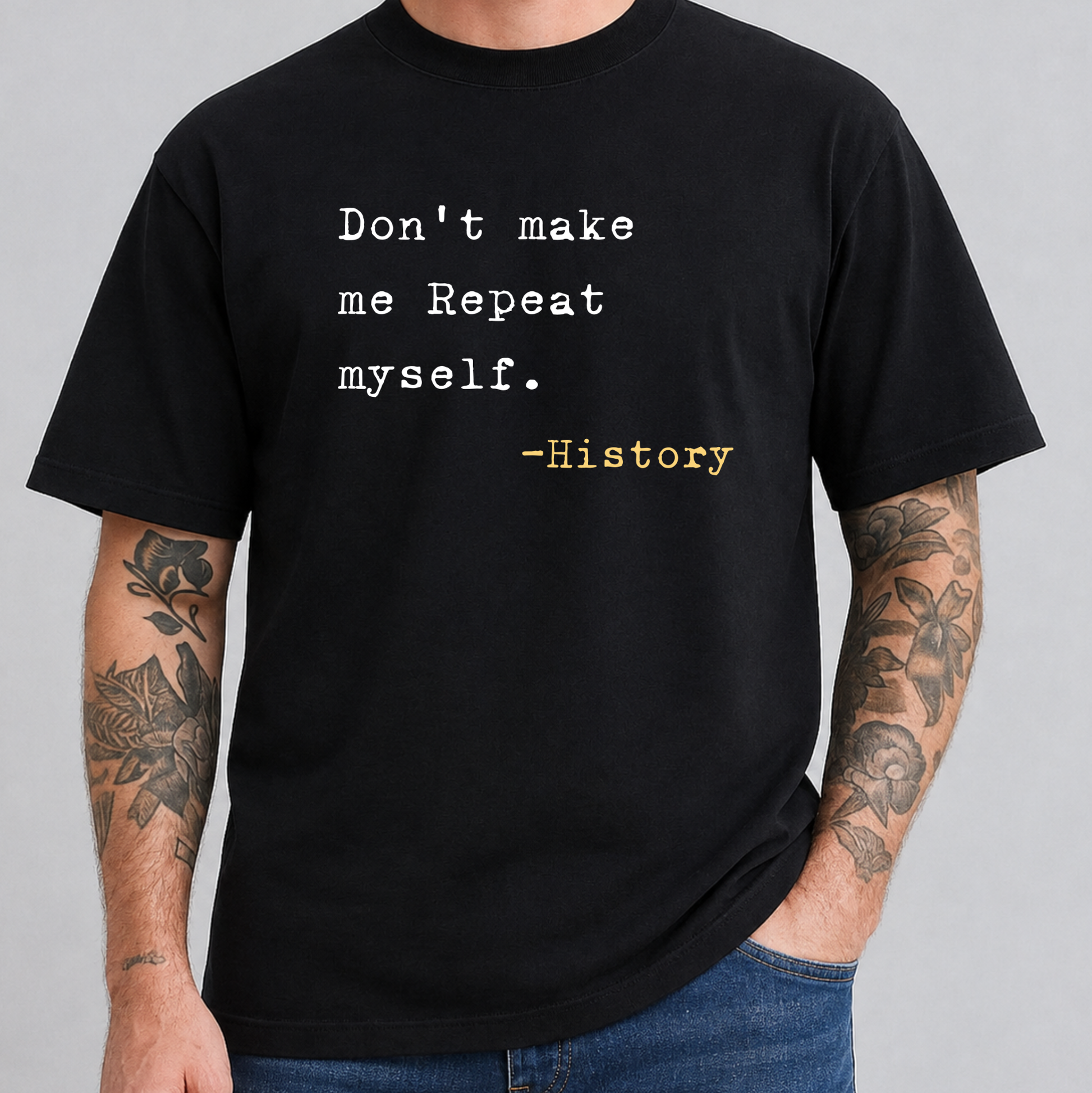 A man wearing a black short-sleeve t-shirt with a typewriter-style printed quote that reads 'Don't make me Repeat myself. -History' in white and yellow text.