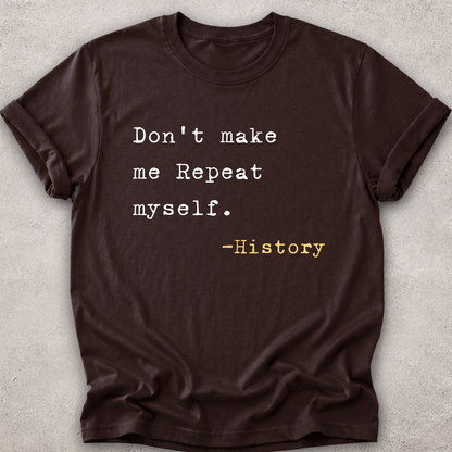 A dark brown short-sleeve t-shirt with a typewriter-style printed quote on the front reading 'Don't make me Repeat myself. -History' in white and yellow text, laid flat on a light gray textured background.
