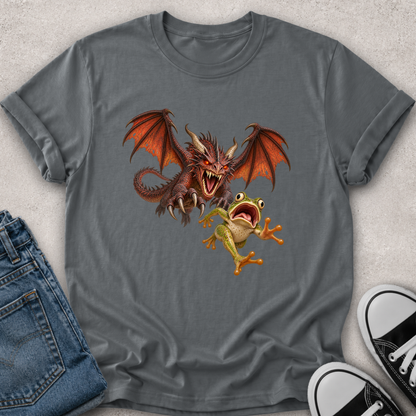 A gray short-sleeve t-shirt with a graphic of a red dragon and a green frog, styled in a flat lay with blue jeans and black-and-white sneakers on a light gray textured background.