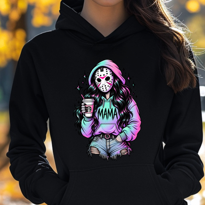 A person wearing a black pullover hoodie with a colorful graphic print of a hockey mask character in a pastel rainbow hoodie and denim shorts holding a drink, with the word 'MAMA' across the chest.