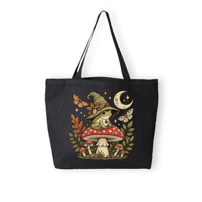 A black canvas tote bag with a whimsical witch frog illustration