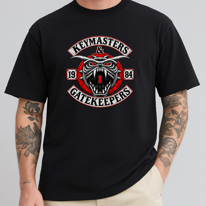 A man wearing a black short-sleeve t-shirt with a large graphic on the chest. The graphic features a snarling red and white horned creature with the words 'KEYMASTERS & GATEKEEPERS' and the numbers '1984'.