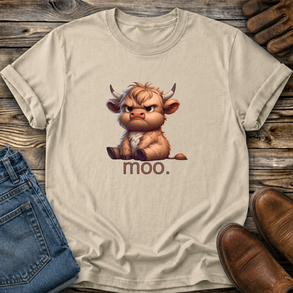 Beige t-shirt with a cartoon bull and 'moo.' text on a wooden surface with jeans and boots.