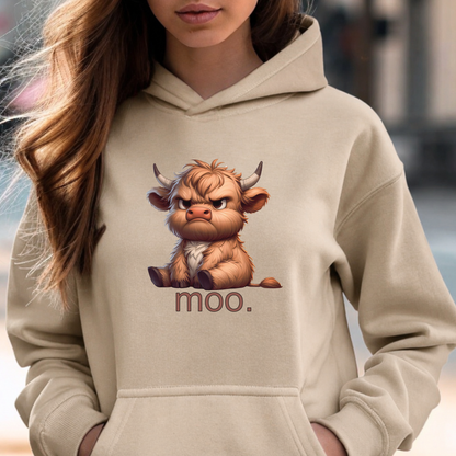 A woman wearing a beige hoodie with a graphic of a fluffy brown cartoon cow and the word 'moo.' printed below it.