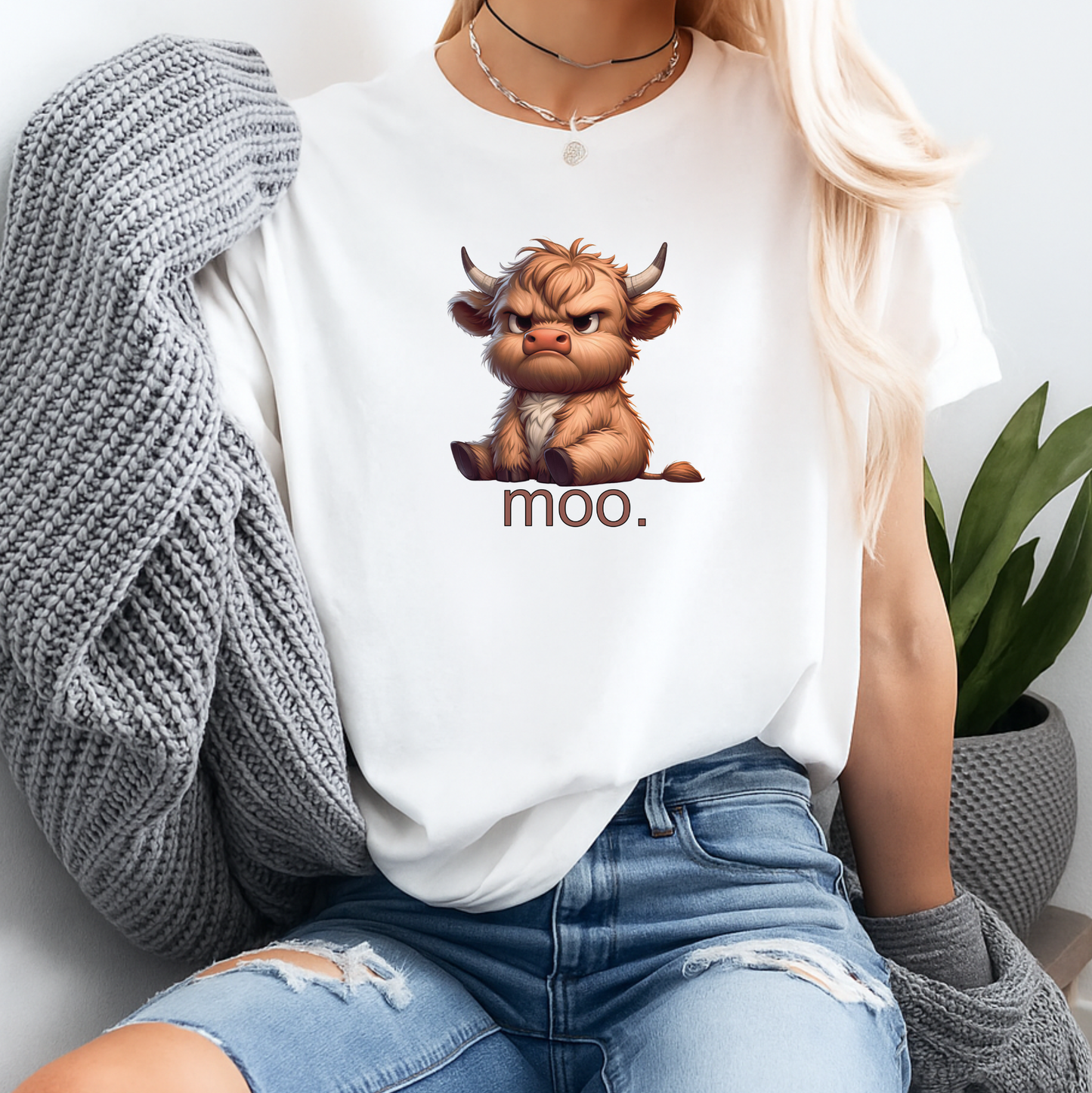 Person wearing a white t-shirt with a cartoon bull and 'moo' text, sitting in a casual setting.