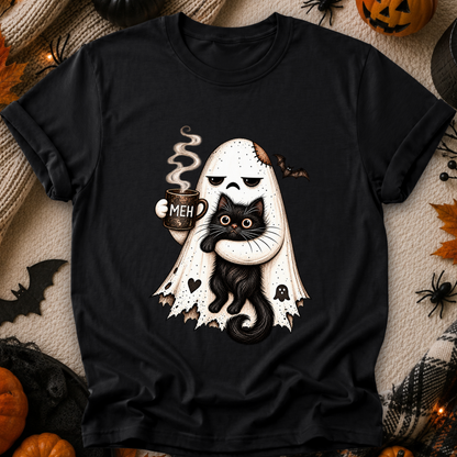 A black short-sleeve graphic T-shirt laid flat on a cozy Halloween-themed background. The shirt features a cute illustration of a ghost-shaped figure with a skull-like face, holding a black cat and a mug that says 'MEH'.
