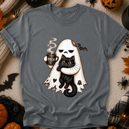 A gray short-sleeve t-shirt with a Halloween graphic of a ghost-shaped pirate holding a black cat and a mug that says 'MEH'. The shirt is displayed flat on a cozy, decorated background with pumpkins, spiderwebs, and autumn leaves.
