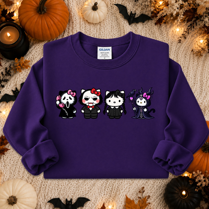 A purple Gildan sweatshirt featuring four cartoon cat characters in Halloween costumes, laid flat on a cozy beige knit blanket surrounded by pumpkins, candles, and autumn decorations.