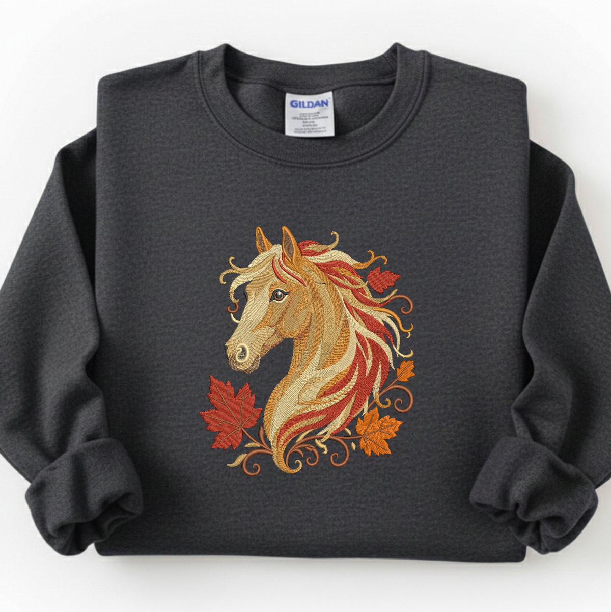 A dark charcoal gray crewneck sweatshirt featuring a graphic of a horse's head with flowing red, orange, and gold hair, accented by autumn leaves. The sweatshirt is laid flat on a white background, showing a Gildan brand tag at the collar.