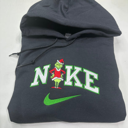 black hoodie with Grinch design and Nike logo on a white background
