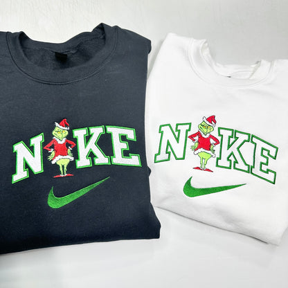 Two Nike sweatshirts with a Grinch design on a white background