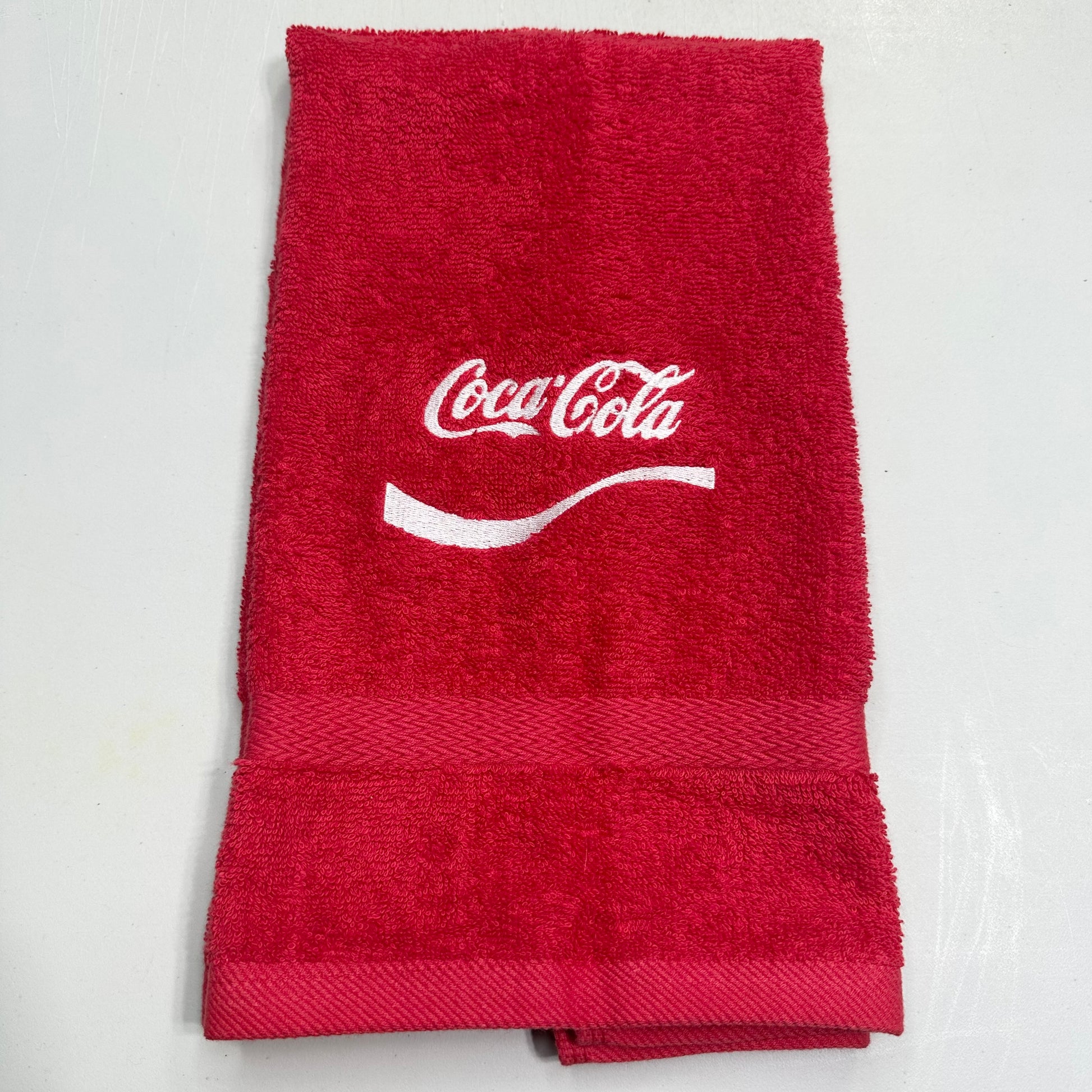 red towel with coca cola embroidered on it