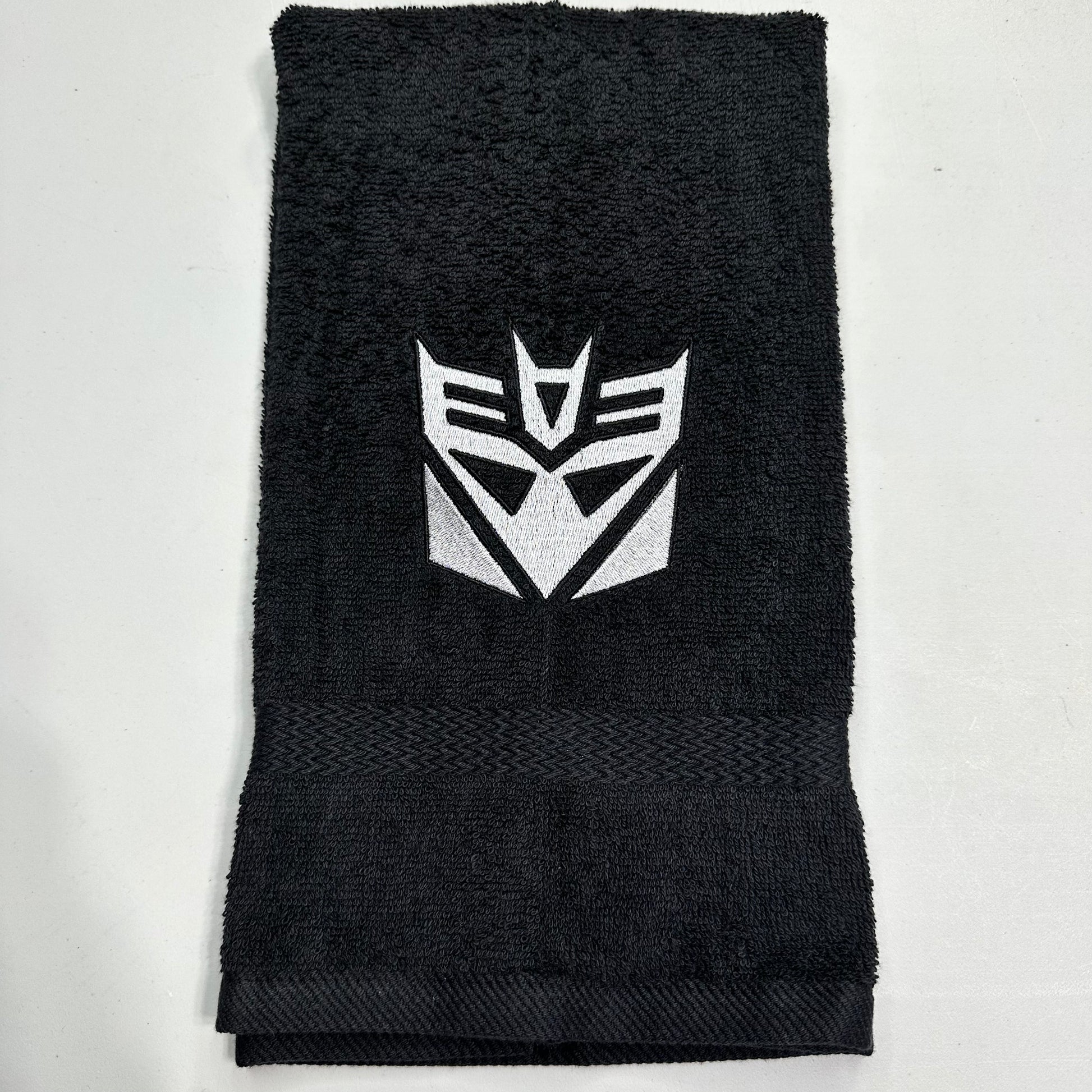 Black towel with decepticon emblem on a light gray background