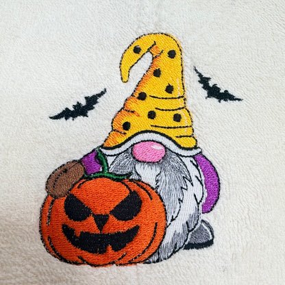 beige towel with an embroidered fall halloween gnome design on it