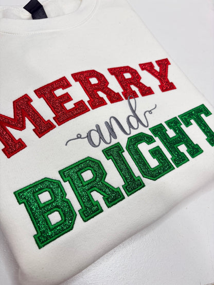 merry and bright in red glitter applique embroidered on a white sweatshirt