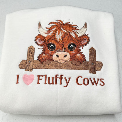 embroidered highland cow with text on a white sweatshirt with a heart
