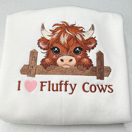 embroidered highland cow with text on a white sweatshirt with a heart