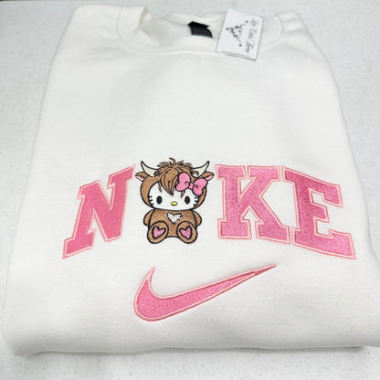 White sweatshirt with pink 'Nike' logo and cartoon character on a white background