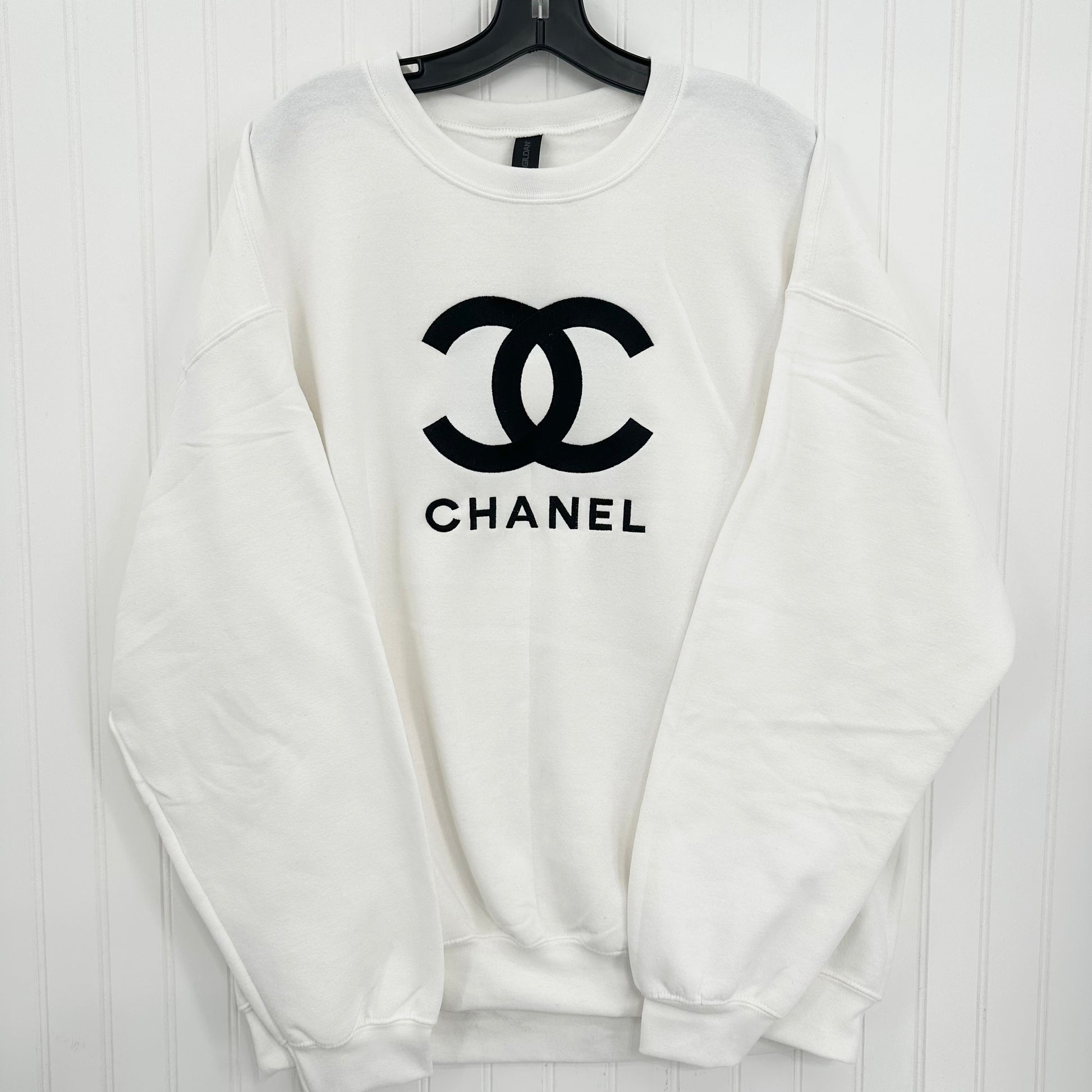 White sweatshirt with black Chanel logo on a white background