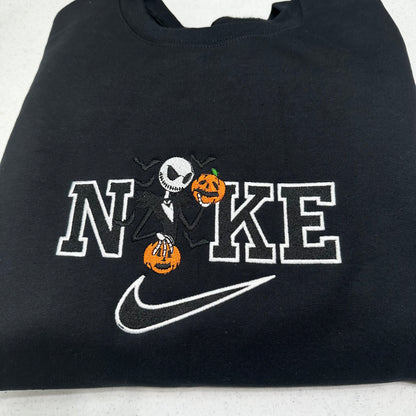 Black sweatshirt with Halloween-themed design featuring 'N' and 'KE' with pumpkins and a skeleton, resembling a well-known brand logo.