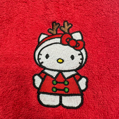 An embroidered Hello Kitty character patch wearing a red holiday outfit with reindeer antlers and a red bow, placed on a textured red fabric background.