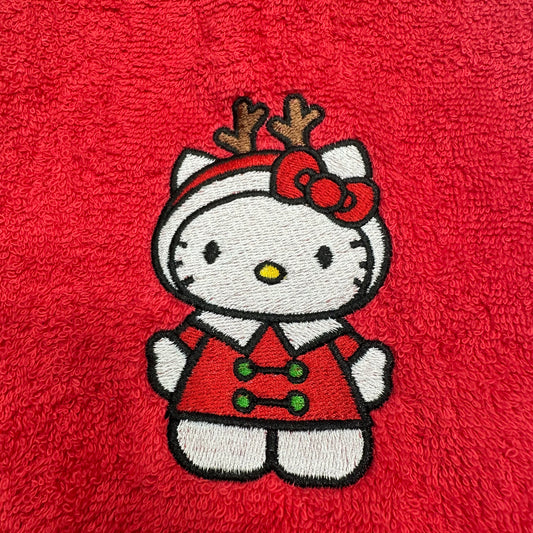 An embroidered Hello Kitty character patch wearing a red holiday outfit with reindeer antlers and a red bow, placed on a textured red fabric background.