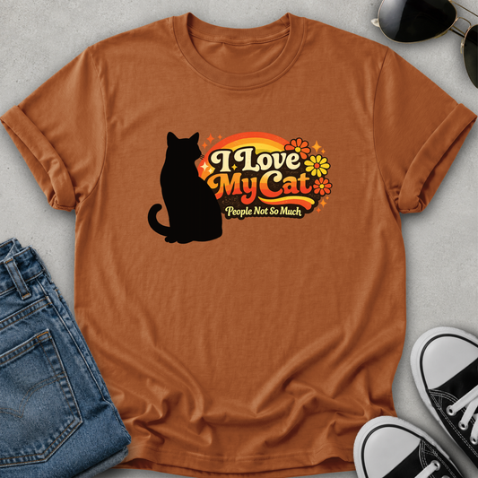 An orange short-sleeve crewneck t-shirt featuring a graphic print of a black cat silhouette next to the text 'I Love My Cat People Not So Much' in retro orange, yellow, and white lettering with small flower details.