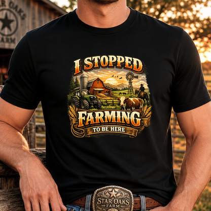 man wearing black tshirt with farm scene graphic that says I stopped farming to be here on it
