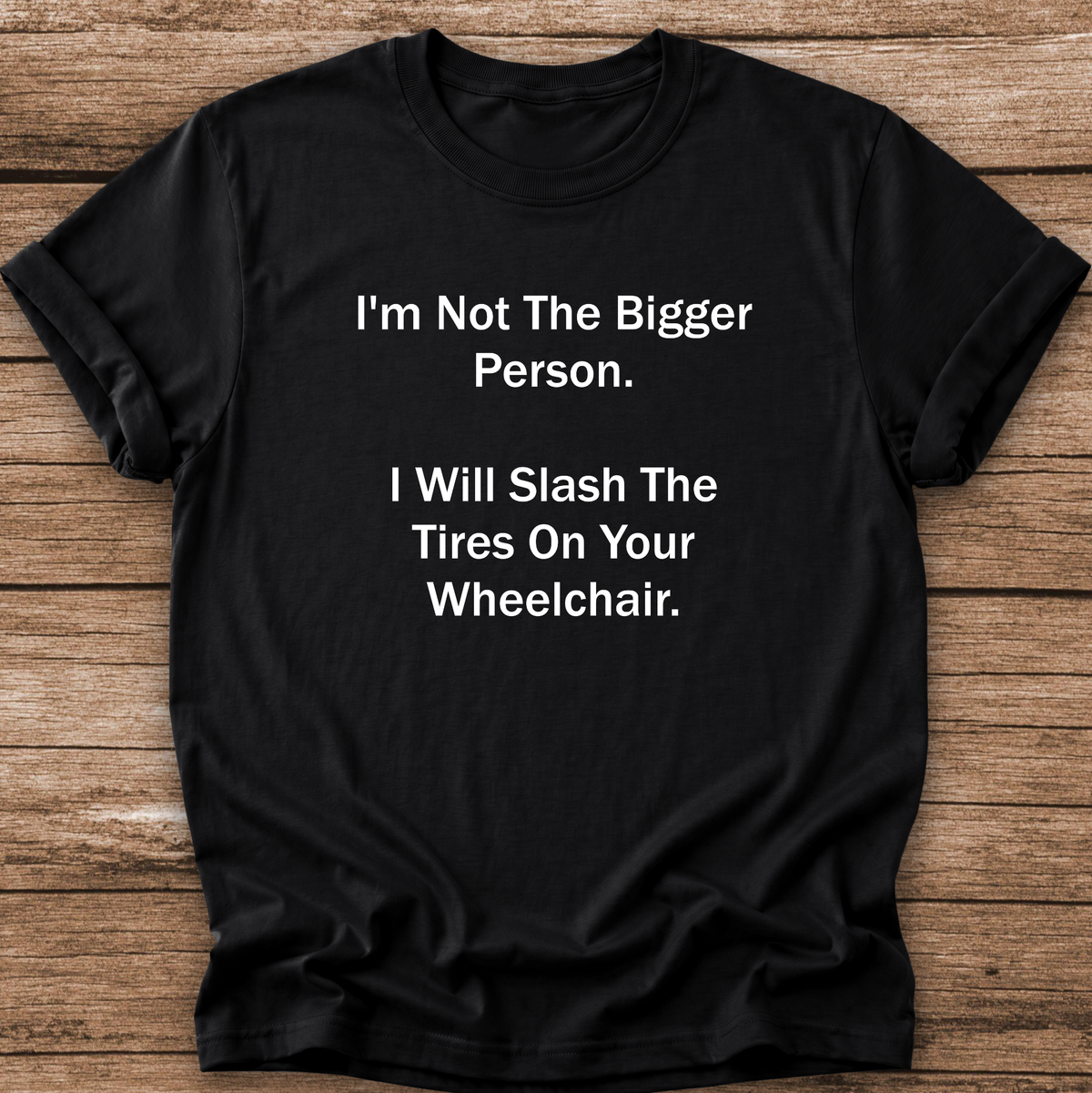 A black short-sleeve crewneck t-shirt with white printed text that reads 'I'm Not The Bigger Person. I Will Slash The Tires On Your Wheelchair.
