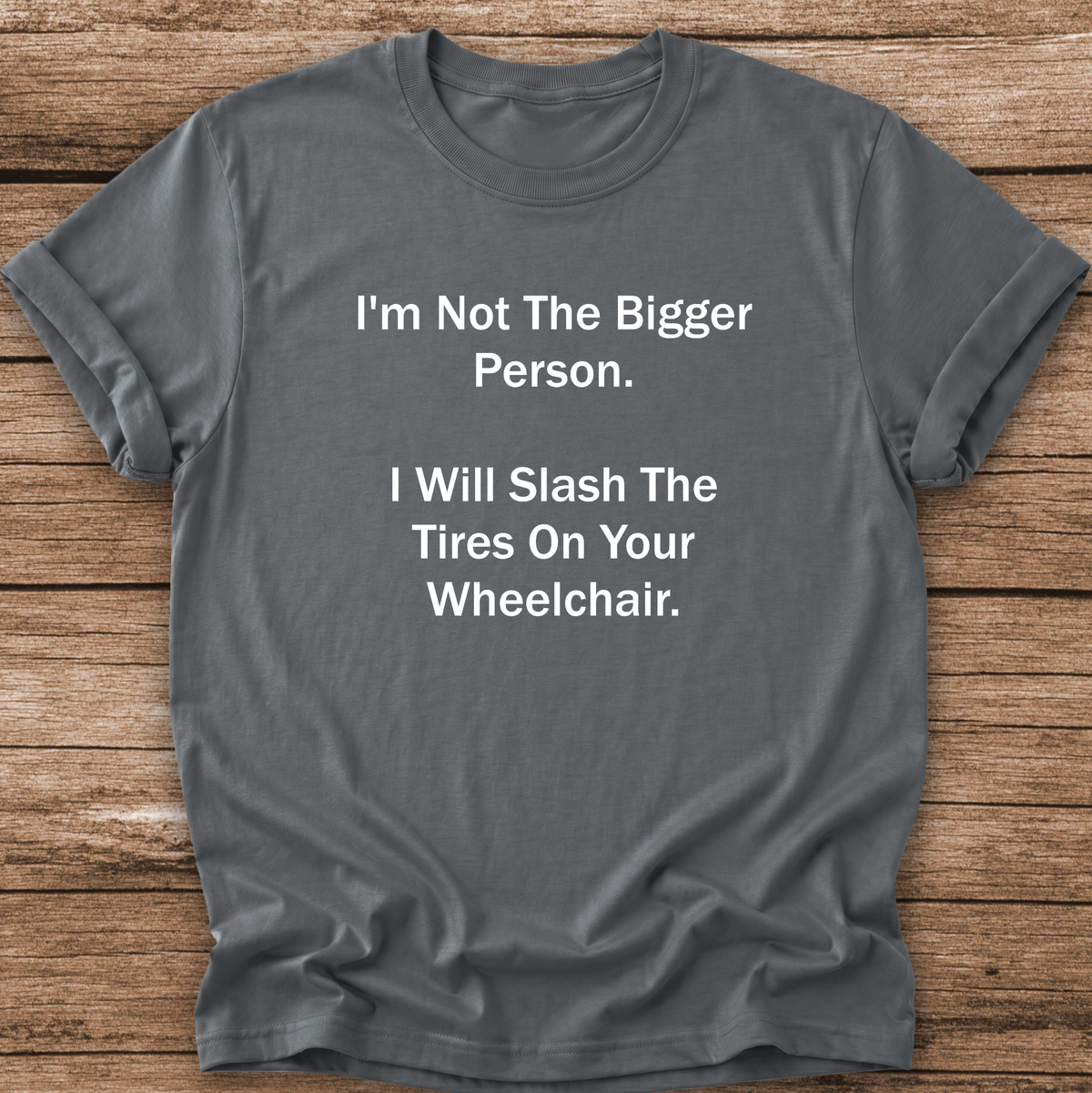 A dark gray graphic t-shirt with white printed text that reads 'I'm Not The Bigger Person. I Will Slash The Tires On Your Wheelchair.