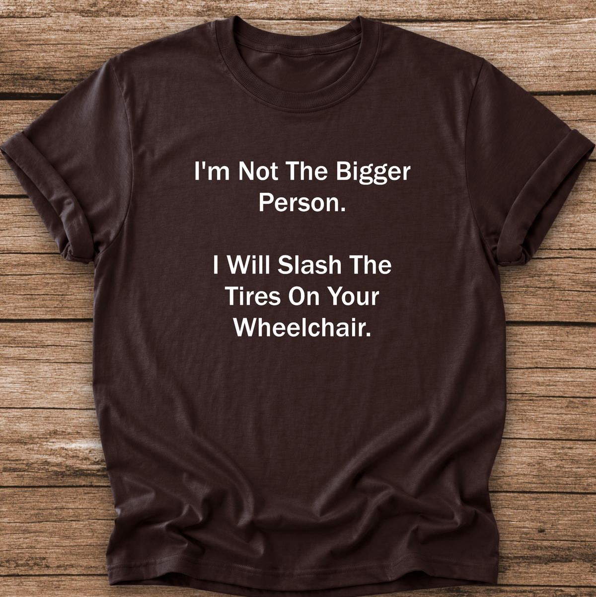 A dark brown short-sleeve t-shirt with white printed text that reads 'I'm Not The Bigger Person. I Will Slash The Tires On Your Wheelchair.