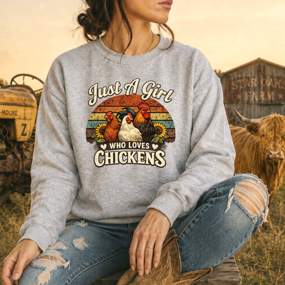 woman wearing a gray sweatshirt with a retro sunset and chickens with sunflowers that says just a girl who loves chickens